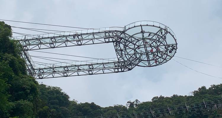 Groot observatiedek met mensen die erop staan boven een beboste klif.
