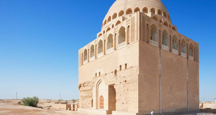 Historic mausoleum with arches and a blue sky background.