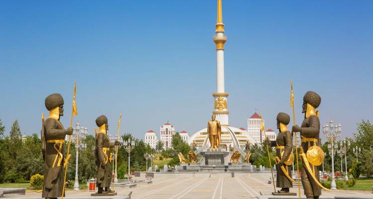 Monument with statues and tall pillars in a clear sky.