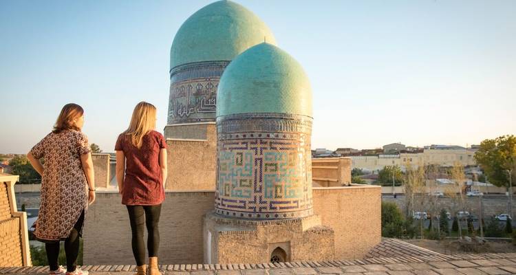 Two women observing ancient domed structures with intricate patterns.