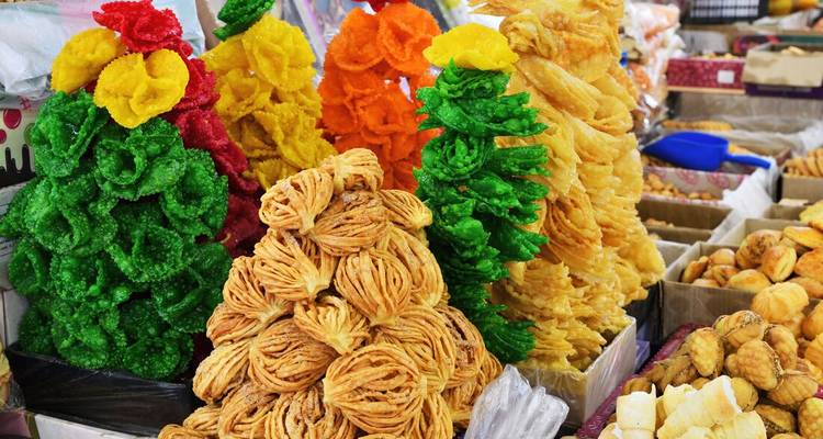 Colorful traditional sweets stacked as trees in a market.