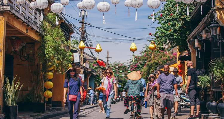 Escena callejera animada con faroles y gente caminando.