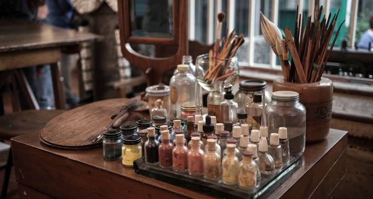 Artist's studio table with paint jars and brushes.