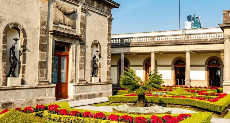 Exterior of a historic building with gardens and sculptures.