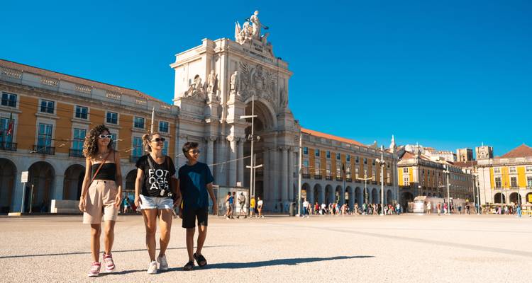 Family walking through an arch in a historic square.