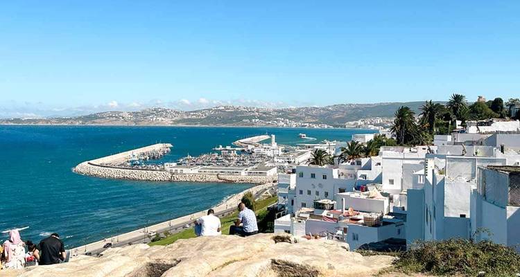 Coastal view of a city with a harbor and blue ocean.