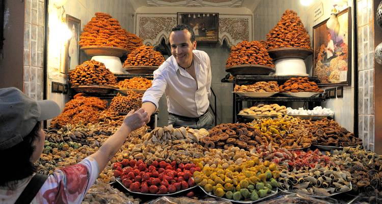 Vendeur de marché vendant des fruits secs et des noix colorés.