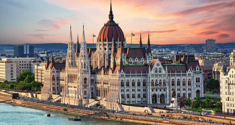 Hungarian Parliament Building along the Danube River at sunset in Budapest.