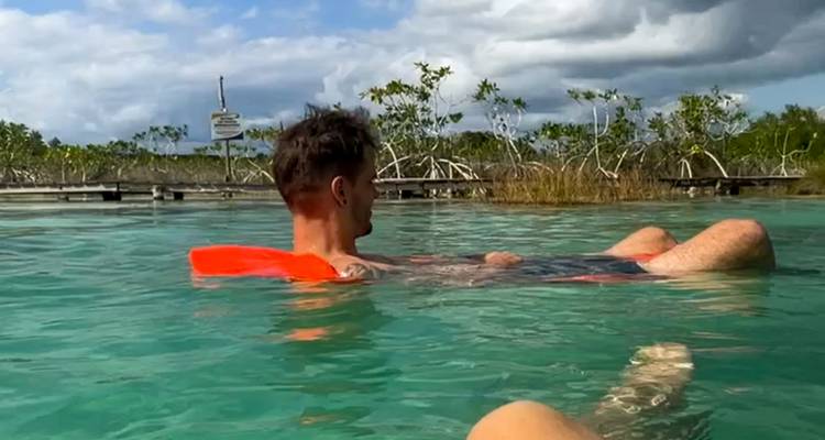 Personne flottant sur l'eau avec un arrière-plan pittoresque.