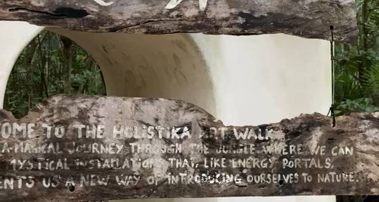 Panneau en bois avec texte dans un environnement forestier.