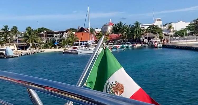 Drapeau mexicain sur un bateau près d'une marina.