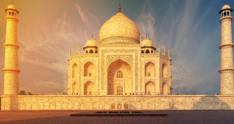 Golden hour at the Taj Mahal with striking colors in the sky.