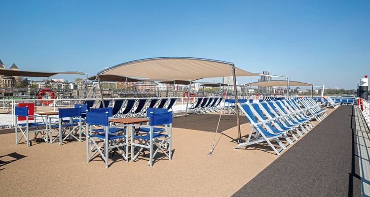 Upper deck of a cruise ship with loungers and a canopy.
