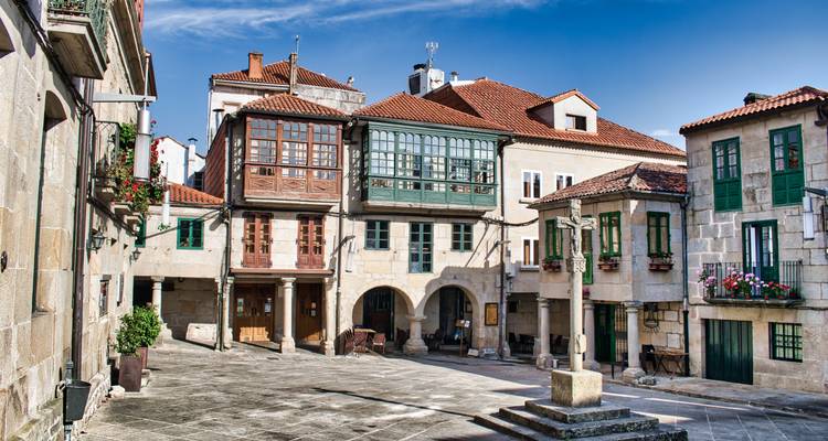Place charmante avec des bâtiments traditionnels en pierre.