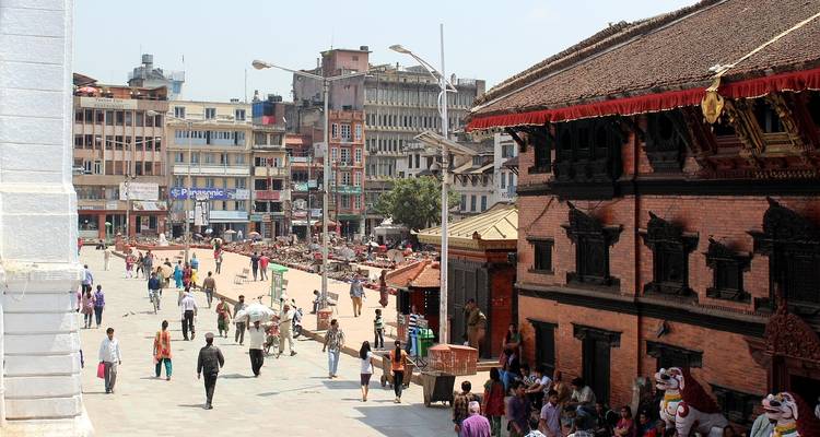 A busy street with historical architecture and people walking.