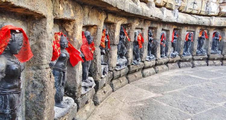 Stone carvings of deities with red cloth.