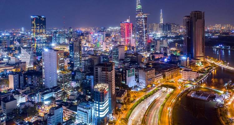Vue aérienne nocturne d'un paysage urbain vibrant et illuminé.