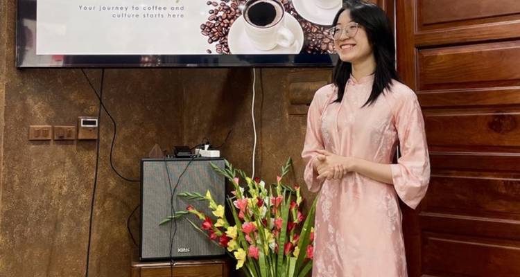 Une femme debout à l'intérieur près d'un étalage avec un thème de café.