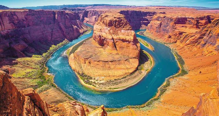 Méandre en fer à cheval avec une rivière qui coule autour d'une formation rocheuse.