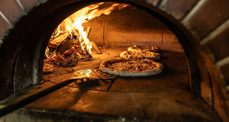 Traditional Neapolitan pizzas baking in a wood-fired oven.