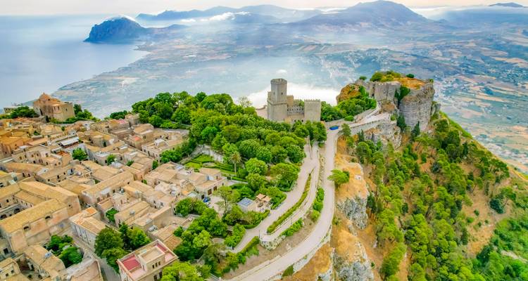 Aerial view of a medieval town on a hilltop with coastal views.