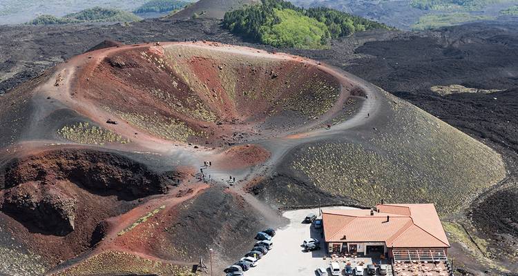 Un cratère volcanique avec des visiteurs explorant le site.