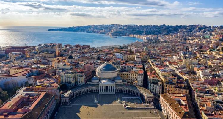 Panorama aérien de Naples avec la Piazza del Plebiscito et la baie majestueuse sous des nuages épars.