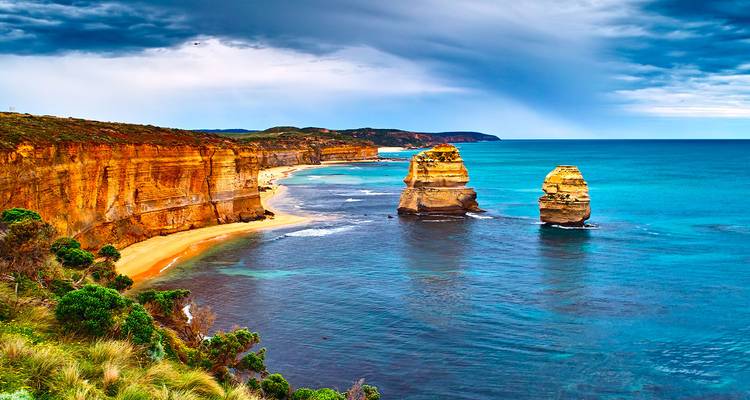 Towering limestone sea stacks rise off golden beaches along Australia’s dramatic coast.
