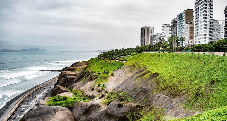 Coastal view with cliffs and modern buildings.