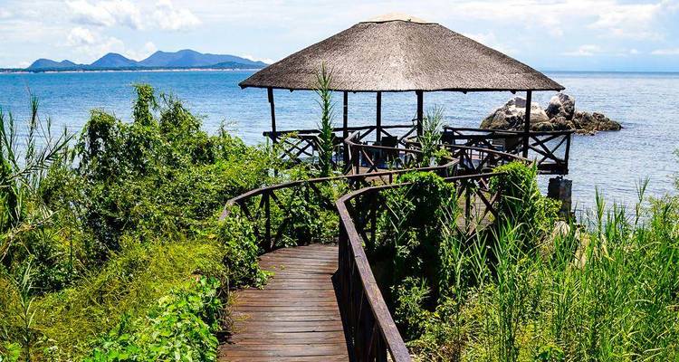 Wooden walkway leading to a gazebo by the lake.