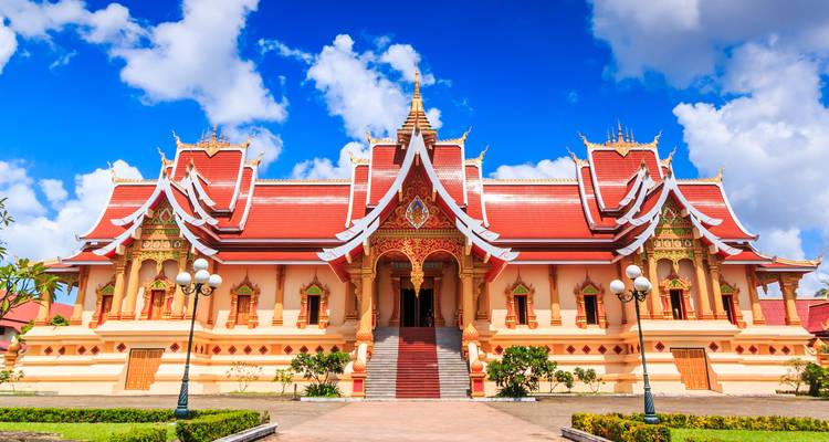 Un temple traditionnel à Vientiane, Laos avec des détails ornés et des couleurs vives.