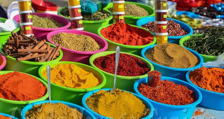 Colorful spices displayed in plastic bowls.