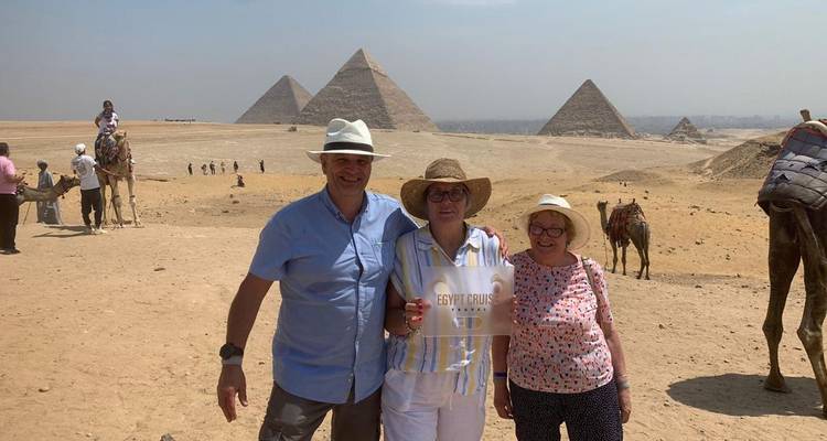 People posing with pyramids in the background at Giza.