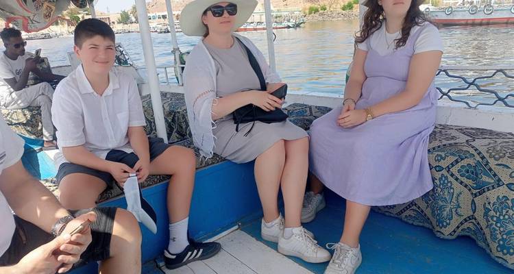 Famille assise sur un bateau avec un arrière-plan pittoresque.