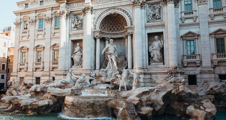 Volledig frontaal zicht op Rome's Trevi Fontein met stromend water, barokke beelden en paleisachtige achtergrond.