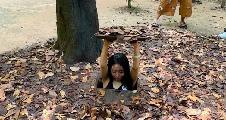 Personne émergeant d'un tunnel camouflé avec des feuilles.