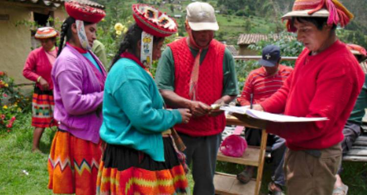 Gente con ropa tradicional colorida intercambiando bienes en un pueblo.