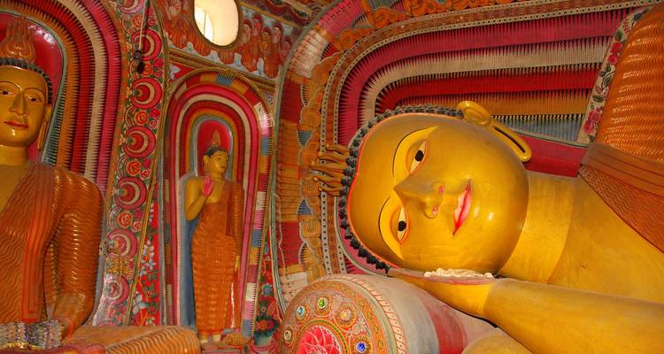 Colorful interior of a temple with reclining Buddha statue.