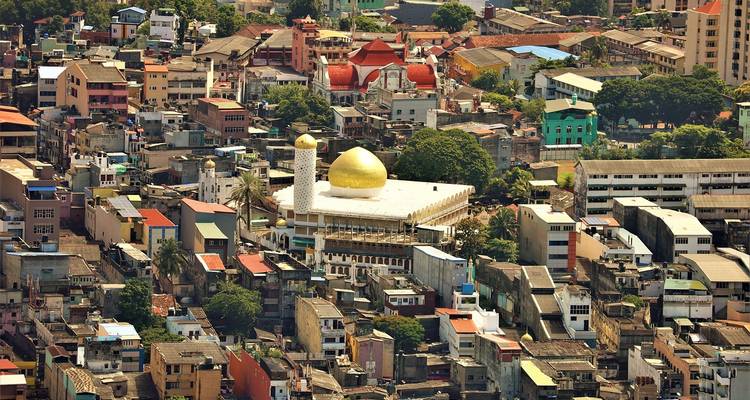 Aerial view of a colorful city with a golden mosque dome.