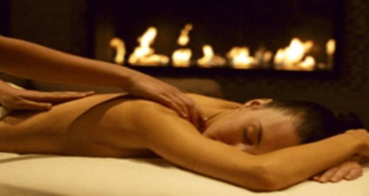 Blurry image of a person getting a massage near a fireplace.