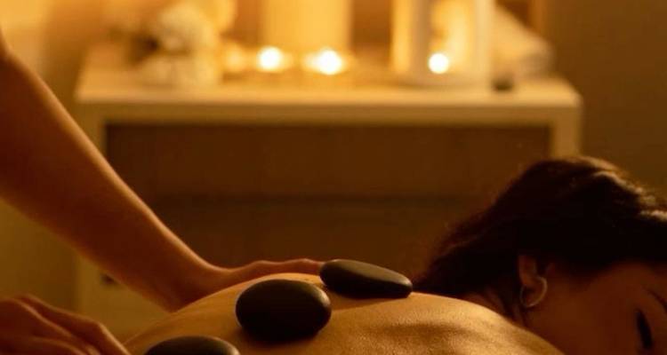 Spa treatment with hot stones on a person's back.