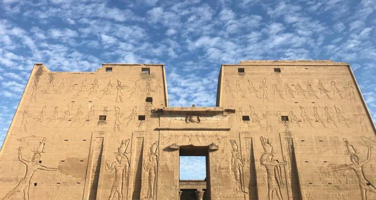 Temple historique avec hiéroglyphes sous un ciel bleu.