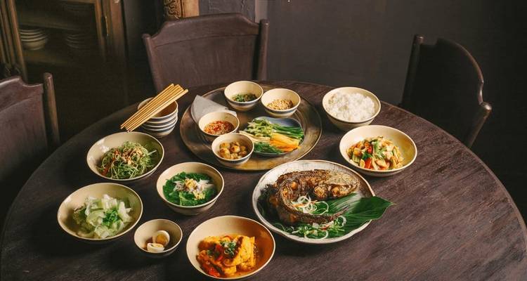 Large éventail de plats vietnamiens sur une table ronde en bois