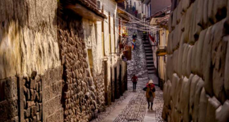 Une rue traditionnelle étroite avec des murs de pierre et des marches.
