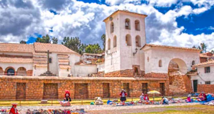 Une scène de marché avec des gens en vêtements traditionnels colorés devant une église.