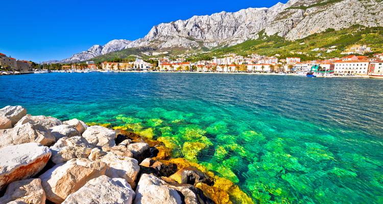 Hermoso paisaje marino con agua turquesa cristalina y edificios coloridos a lo largo de la orilla.