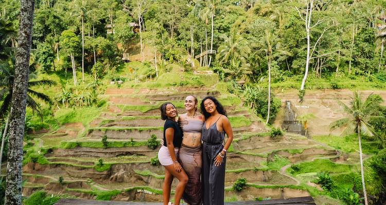 Three people posing at the picturesque rice terraces in Bali.