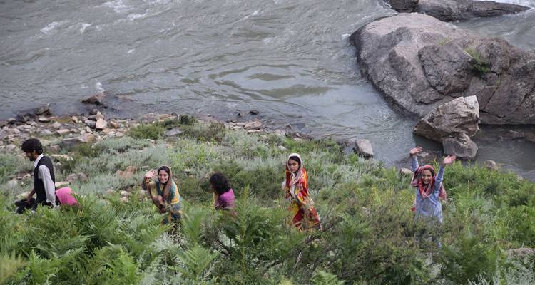 Groupe d'enfants debout près d'une rivière.