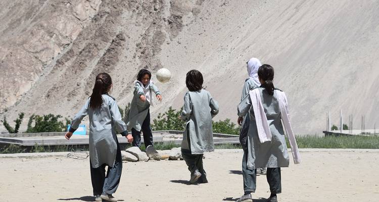 Groupe d'enfants jouant avec un ballon dans un village de montagne.
