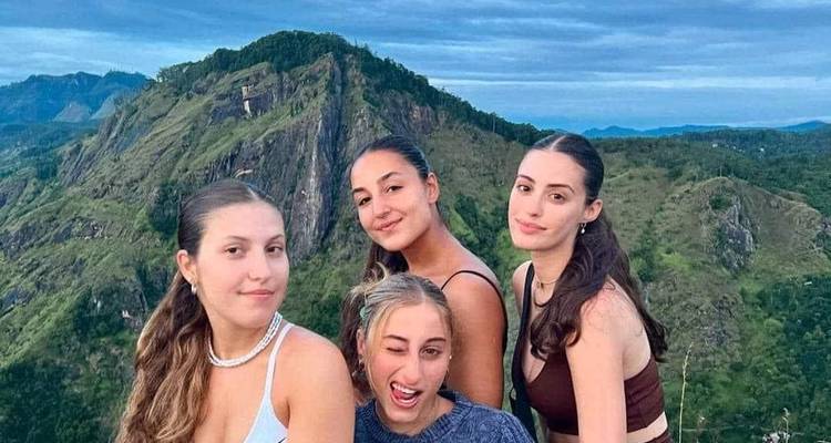 Group of women posing with a mountain backdrop.